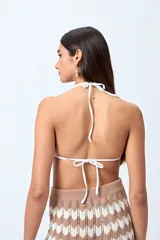 Top de bikini blanco con tirantes finos ajustables al cuello y a la espalda. Presenta volados en el escote y está confeccionado en tejido suave con acabado elástico.