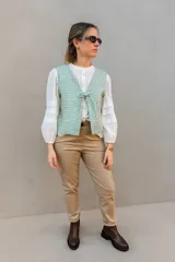 Chaleco reversible con escote en V y lazo para ajustar, confeccionado en lino italiano con sutil brillo. Un lado es a cuadros en tonos verde agua y amarillo, y el otro es liso color crudo.