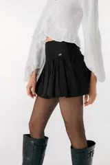 Minifalda negra con volados y detalle de etiqueta con logo en el lateral.