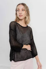 Buzo negro de punto abierto con diseño calado, mangas largas abullonadas y cuello redondo.