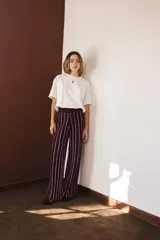 Pantalón palazzo color borgoña con rayas verticales finas color crema, de tejido liviano con lurex y cintura elastizada.