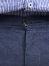 Bermuda color beige claro, de corte casual y largo por encima de la rodilla, con bolsillos laterales.