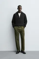 Jersey de punto perlado negro, de corte relaxed fit, con cuello perkins y cierre frontal de cremallera.