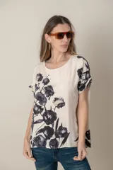 Blusa italiana de calce holgado, talle único, con cuello redondo y mangas cortas. Estampado de flores sobre fondo natural.