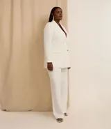 Blazer de poliéster color blanco, de corte sastrero, con cuello solapa, botón dorado redondo contrastante, manga larga con botón y bolsillos fake de solapa delanteros.
