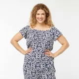 Blusa con escote bardot, estampado abstracto en azul y blanco, mangas cortas y cintura elástica.