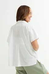 Camisa gris sin mangas de lino con cuello clásico y cierre frontal con botones.