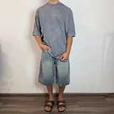 Remera gris con efecto lavado, corte oversize y mangas 3/4.