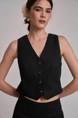 Chaleco marrón con escote en V y cierre frontal con botones.