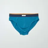 Pack de tres slips de hombre, uno azul marino con estampado geométrico, uno azul liso y uno azul con rayas horizontales y estampado geométrico.