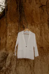 Blazer color crudo confeccionado en lino, con corte recto, solapas clásicas y cierre frontal con un botón.