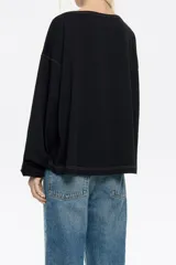 Camiseta negra de manga larga con corte holgado, cuello redondo y pespuntes a contratono.