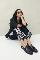 Pantalón recto negro de algodón con bordado artesanal blanco a contratono en los laterales y ruedo.