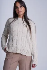 Sweater color crema tejido con diseño de trenzas y calados en el ruedo.