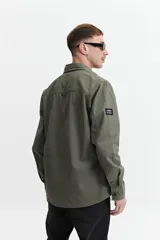 Sobrecamisa color marrón claro de twill de algodón, con cuello clásico, cierre frontal con botones a tono, dos bolsillos de parche con solapa abotonada en el pecho y mangas largas con puños abotonados.