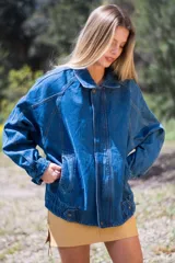 Campera oversize de jean azul con cierre frontal y bolsillos con solapa.