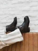 Bota corta de cuero color marrón oscuro con hebilla lateral y suela track.