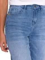 Pantalón de jean celeste claro con rotura en la rodilla, corte recto y diseño de cinco bolsillos.