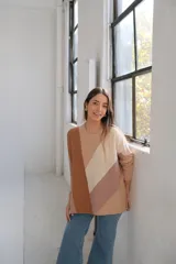 Sweater de punto con cuello redondo y corte murciélago. Diseño con bloques de color diagonales en tonos beige, marrón y tostado.
