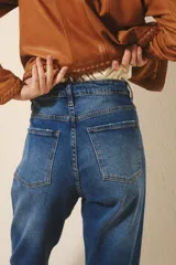 Jean tiro alto de denim azul con elastano, lavado localizado con bigotes y pierna recta.