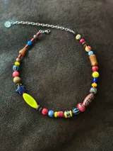 Collar corto con cuentas de cristal checo, cerámica, madera y otros materiales. Se cierra con cadena y ganchito para regular el largo.