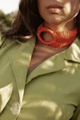 Gargantilla tejida a crochet con hilo de seda viscosa color naranja, con diseño circular.