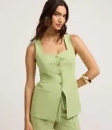 Chaleco sastrero color verde lima, con escote cuadrado y detalle de corazón en el busto, abotonado al frente con botones dorados. Presenta pinzas delanteras y bolsillos falsos.