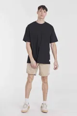 Remera negra de manga corta, corte holgado y cuello redondo. Presenta un pequeño detalle de etiqueta blanca en el borde inferior izquierdo.