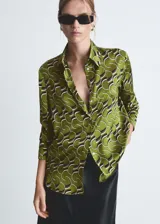 Camisa de manga larga con puños abotonados, de tejido satinado color verde con estampado abstracto en blanco y negro.