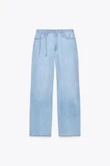 Pantalón de denim de tiro medio, color celeste claro lavado, con calce ancho y recto. Presenta cintura elástica ajustable con cordón anudado en el frente.