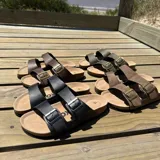 Sandalias de cuero sintético color verde militar, con plantilla marrón y hebillas metálicas doradas.