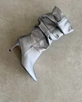 Bota plateada de caña alta con efecto arrugado y taco aguja.