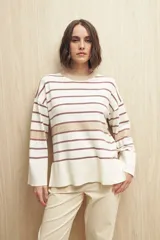 Sweater de rayas horizontales color crudo y marrón, con cuello redondo a contratono color beige, tajos laterales y mangas largas con puño ancho.