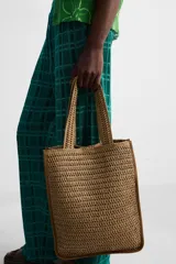 Bolso tipo shopper color marrón claro, con acabado trenzado. Tiene un compartimento principal con cierre de imán y un bolsillo plano interior. Cuenta con dos asas de mano.
