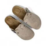 Zuecos color beige con hebilla ajustable.