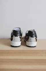 Championes negros de cuero con detalle de estrella plateada y talón plateado.