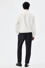 Pantalón tobillero azul marino de sarga suave con cintura elástica y cordón ajustable. Tiene bolsillos laterales y traseros ribeteados, piernas con pliegues cosidos y doblez en el bajo.