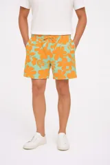 Short de baño o casual con estampado hawaiano de flores grandes en color naranja sobre fondo verde menta. Posee cintura elástica con cordón ajustable.