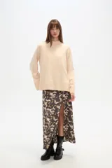 Sweater de viscosa color beige, con cuello polera, corte holgado y pespuntes decorativos en el frente.