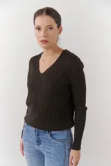 Sweater de punto marrón con escote en V y mangas largas.
