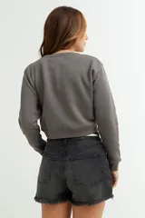 Sweatshirt azul marino de corte cropped y manga larga.