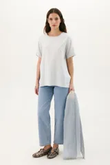 Blusa celeste de manga corta con cortes laterales y abertura abotonada en la espalda.
