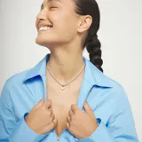 Collar con cadena de aleación de metales bañada en plata de ley, con un dije colgante en forma de corazón bañado en oro 18k y un pequeño detalle de cristal incrustado.