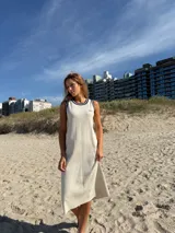 Vestido tejido en algodón color crudo, sin mangas, con cuello redondo y ribete azul marino.