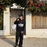 Buzo negro de algodón con cierre frontal, cuello alto y estampado blanco con la inscripción "LOOKMOM STUDIOS Seduce & Destroy".