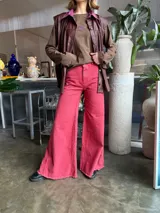 Pantalón jean fucsia de tiro medio, corte wide leg con godets y ruedo desflecado.