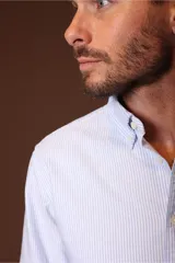 Camisa blanca de manga larga con cuello abotonado.