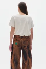 Remera color crudo de algodón lavado con cuello redondo, manga corta y calce oversized. Estampado frontal con dos flores abstractas en color celeste.