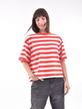 Remera blanca con rayas horizontales rojas, de corte holgado y mangas cortas.