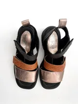 Sandalias de cuero multicolor (negro, marrón y dorado) con tiras ajustables con velcro y suela de goma. Elaboradas artesanalmente en Uruguay.